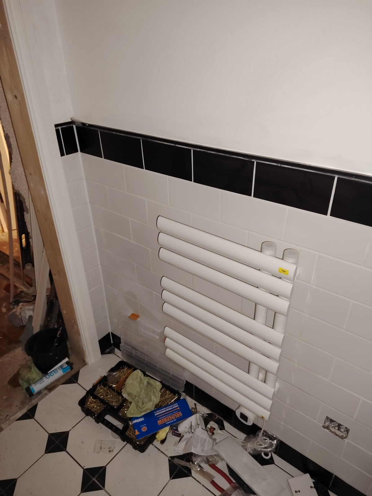 Electric radiator hung on the bathroom wall; work in progress.