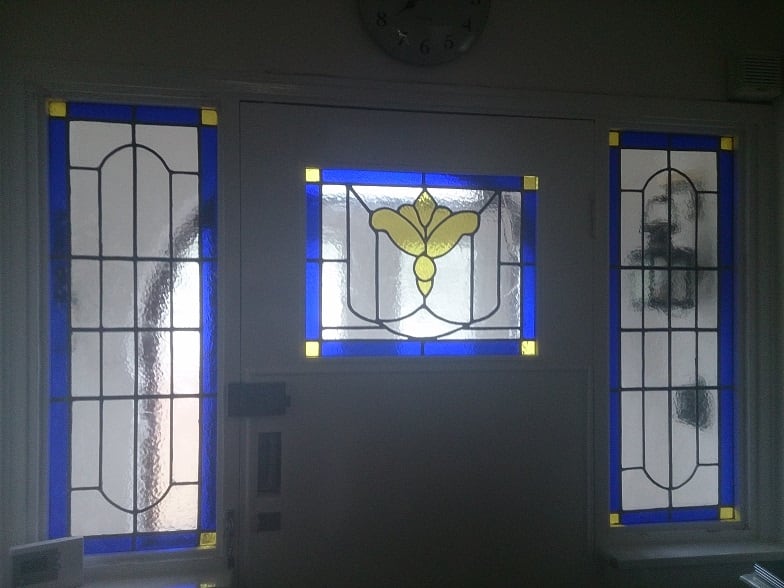 Stained-glass door and side panels with blue borders and yellow details.