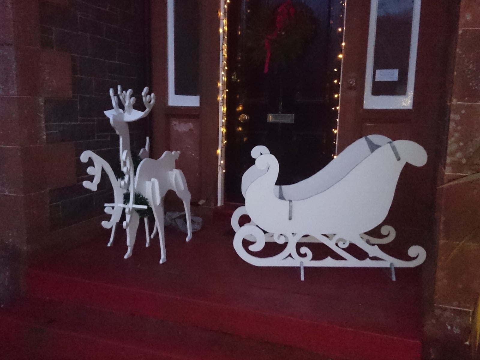Painted freestanding sleigh and reindeer decorations.